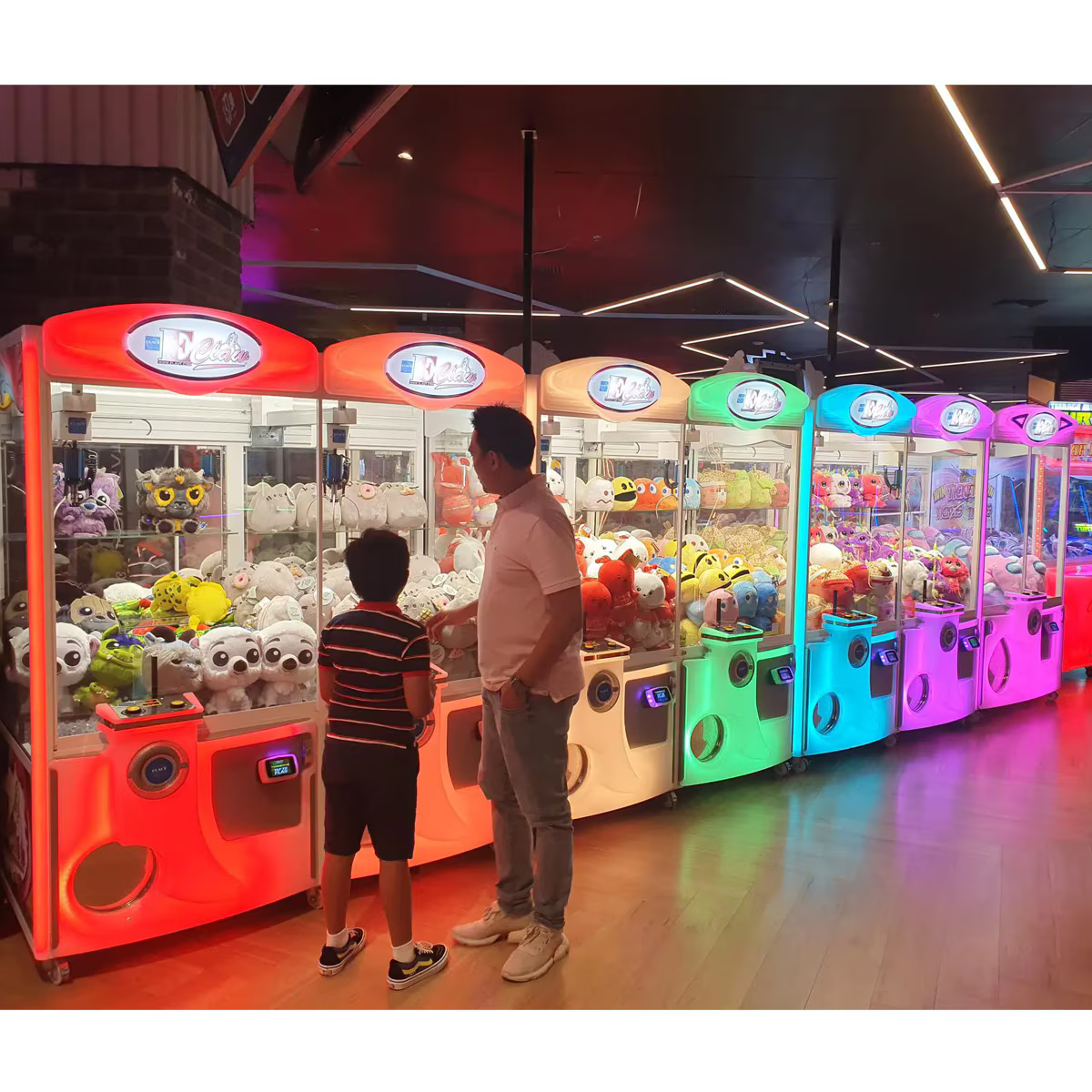 E-Claw 900 Crane Claw Machine Arcade Game Multiple Machines Bright Rainbow Colors Players Having Fun