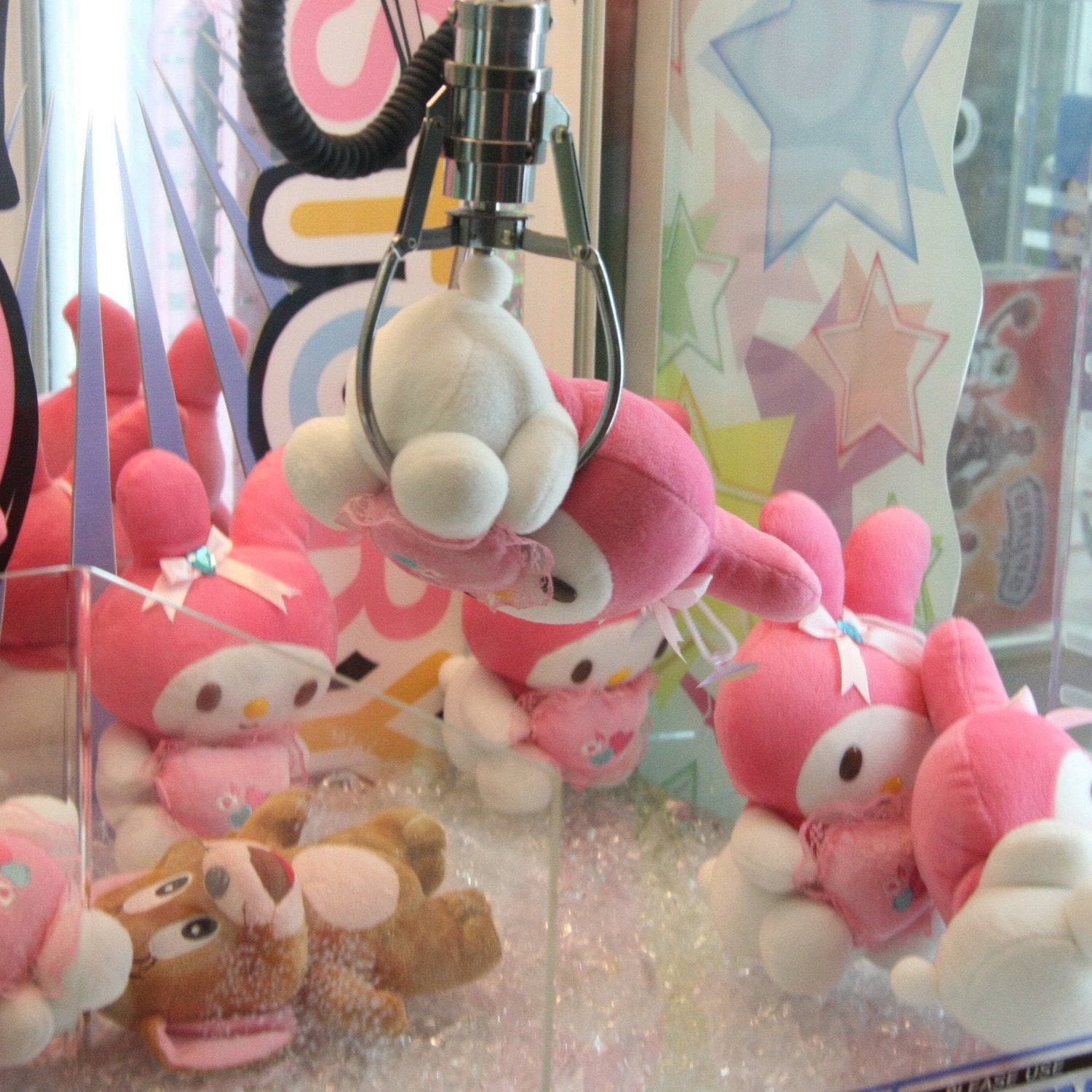 Stuffed animal being picked up by the claw in a crane machine