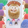 Real hedgehogs display card with green, pink, purple, blue and brown hedgehogs